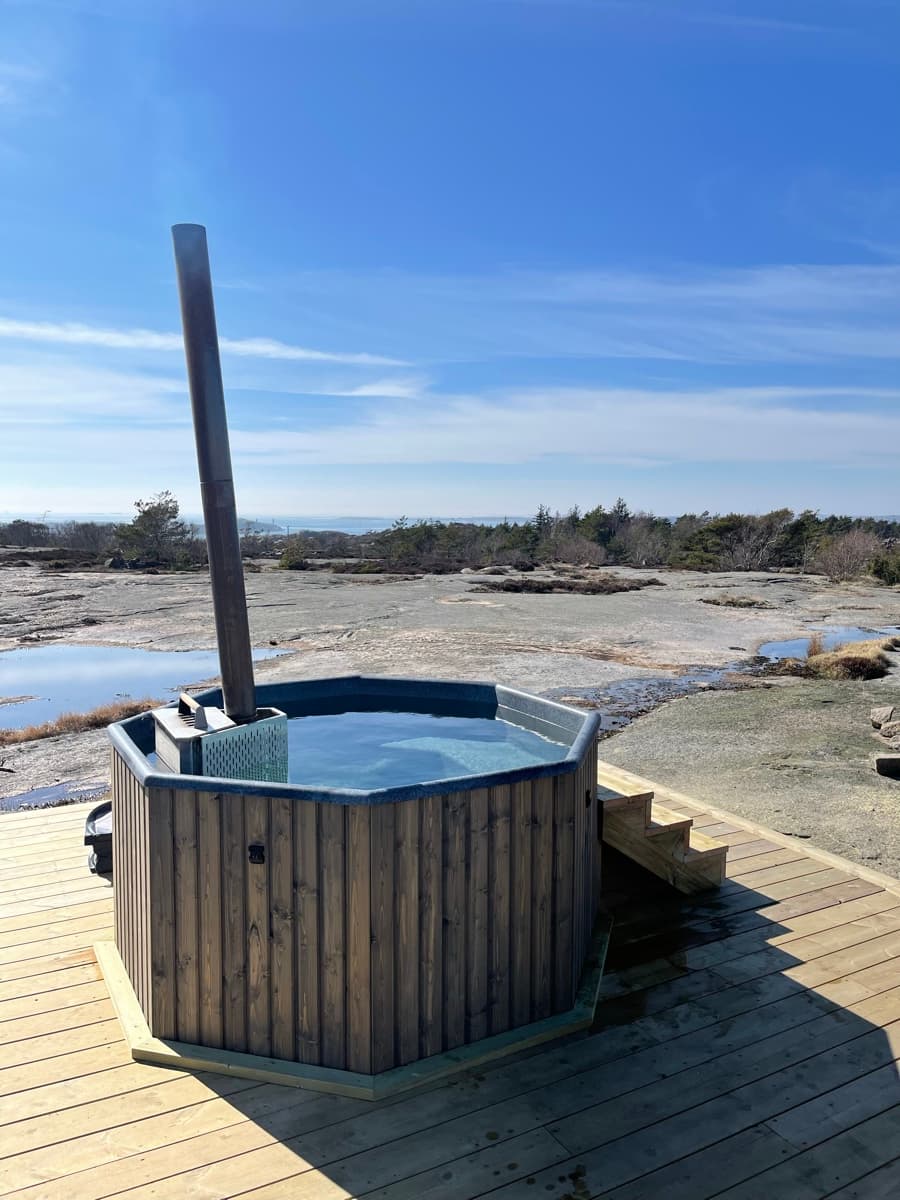 Ångande badtunna på klippor i Bohuslän under kvällsljus